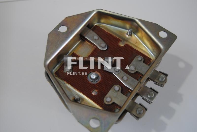 The product features a metallic housing with a brown insulating material and metal components. There is a hole in one corner for a screw attachment. Metal tabs are positioned on the plate.
