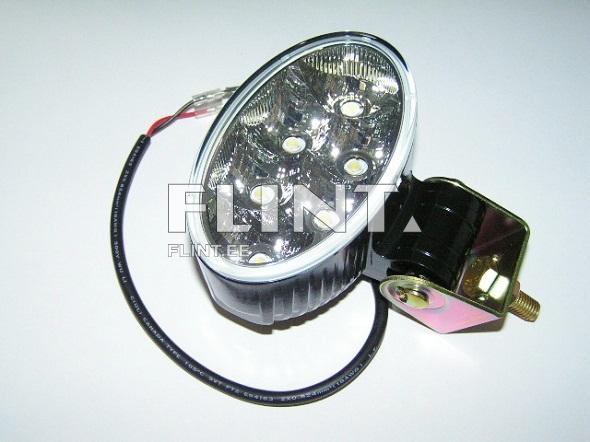 The object is an oval LED light featuring five bright bulbs. It has a black and silver color scheme, with a wire for connection.