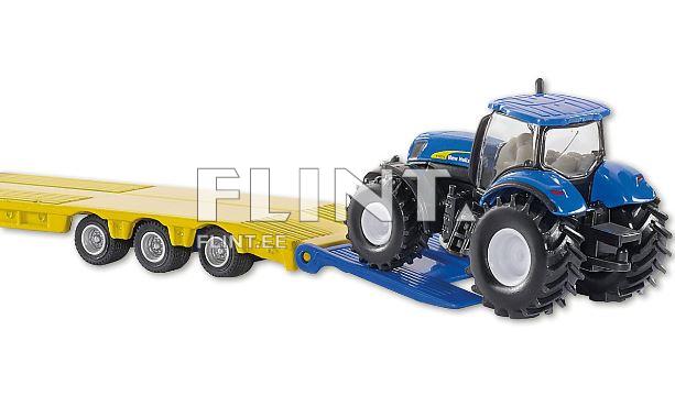 Pildil on sinine traktor, mis seisab kollase kaubaveo platvormi peal. Traktoril on suured mustad rehvid ja selged detailid, sealhulgas esiklaas ja kabiin.